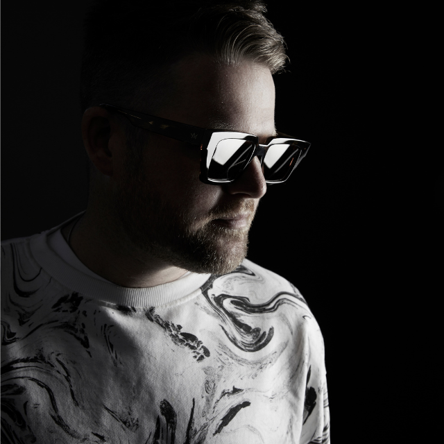 Opiuo wearing sunglasses in front of a black background