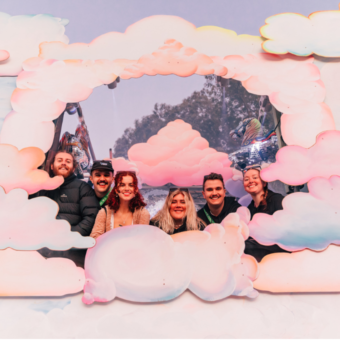 Friends posing in an art installation of clouds