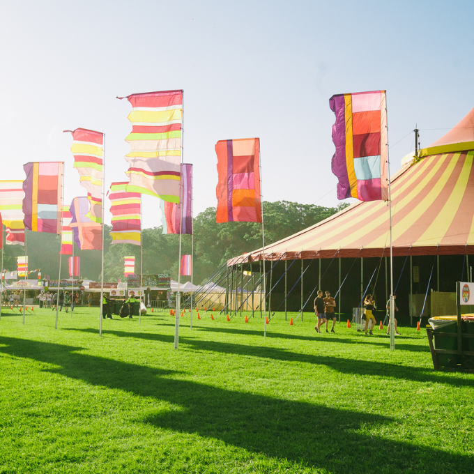 A tented stage with flags in the background at Splendour in the Grass.